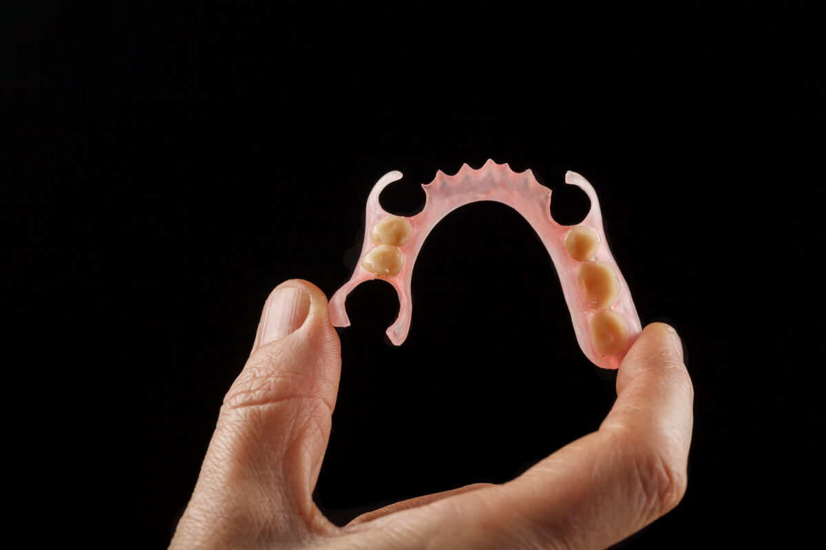 Removable dentures : Image showing a flexible denture in the hands of a dentist